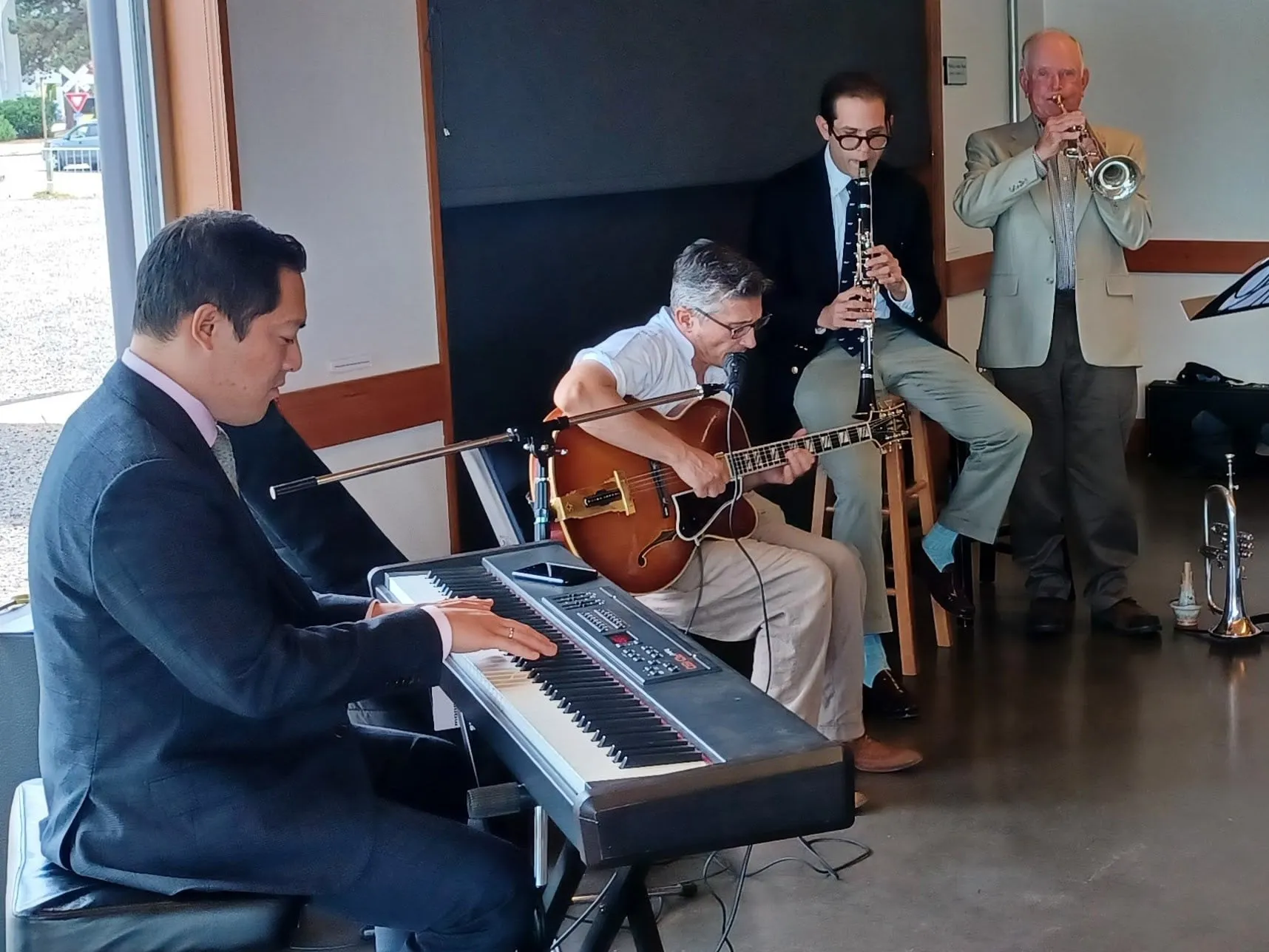 Aaron Johnson performing with a keyboard player, guitarist and horn player at a daytime gig.